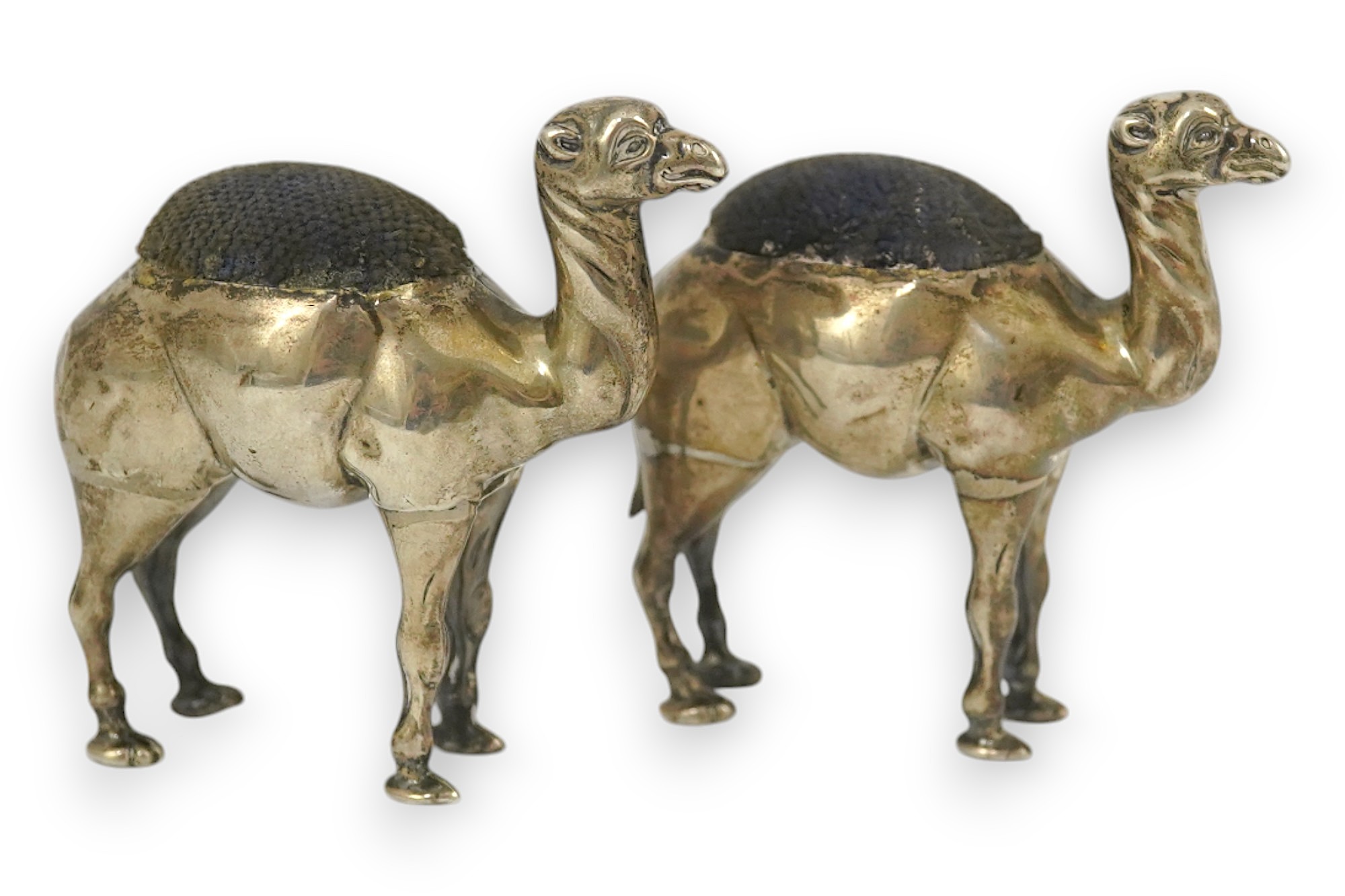 A pair of Edwardian novelty silver pin cushions, each modelled as a camel